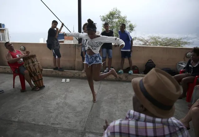 A girl dances on a rooftop in the Cantagalo favela of Rio de Janeiro, Brazil, August 7, 2016. (Photo by Pilar Olivares/Reuters)