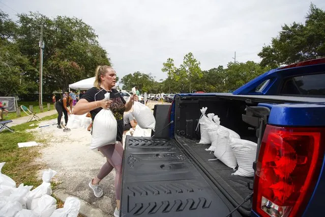 Victoria Colson, 31, of Tampa loads sandbags into her truck along with other Tampa residents who waited for over 2 hours at Himes Avenue Complex to fill their 10 free sandbags on Sunday, September 25, 2022, in Tampa, Fla. (Photo by Luis Santana/Tampa Bay Times via AP Photo)