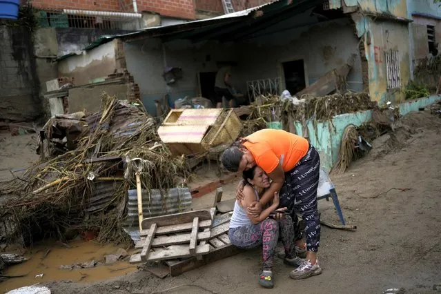 A neighbor, right, comforts a woman crying in front of her damaged home by flooding in Las Tejerias, Venezuela, Sunday, October 9, 2022, after days of heavy rains caused the overflow of a river. (Photo by Matias Delacroix/AP Photo)