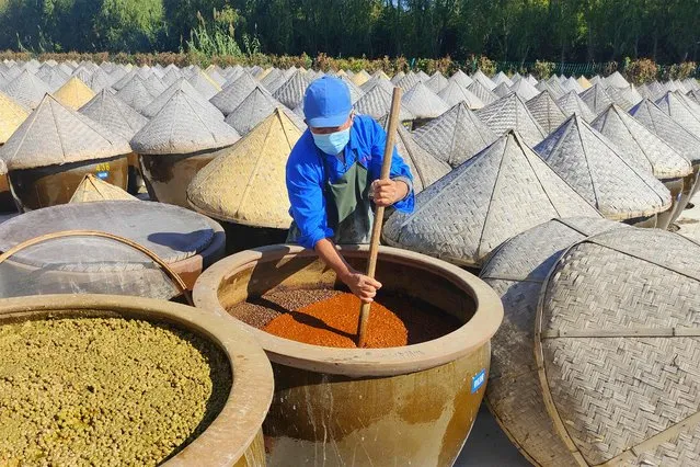 This photo taken on October 19, 2022 shows a worker producing soy sauce in Rugao in China's eastern Jiangsu province. (Photo by AFP Photo/China Stringer Network)