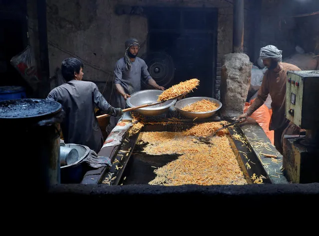 Men cook chips at a small traditional factory in preparation for Eid al-Fitr, marking the end of the fasting month of Ramadan amid the spread of the coronavirus disease (COVID-19), in Kabul, Afghanistan on May 21, 2020. (Photo by Mohammad Ismail/Reuters)