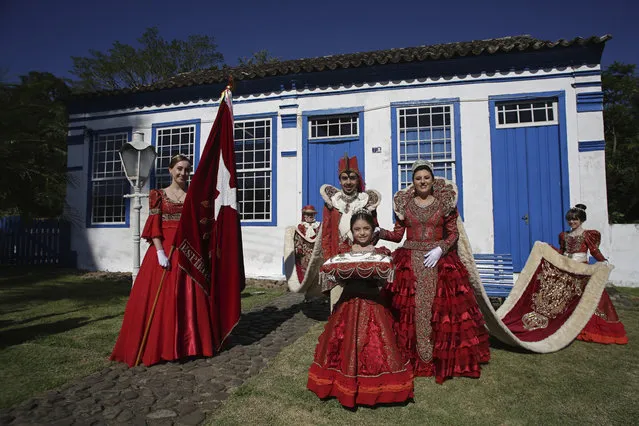 In this November 12, 2017 photo, residents dressed in red robes and wearing crowns that represent the Portuguese emperor and his wife pose for a portrait during the Azorean Culture Festival which celebrates the culture of the Azores, the Portuguese island chain that lies in the mid-Atlantic, in Enseada de Brito, in Brazil's Santa Catarina southern state. In the mid-18th century, several families from the archipelago migrated to settle here, and the festival reflects the resulting mix of Azorean culture and the native and African traditions in Brazil. (Photo by Eraldo Peres/AP Photo)