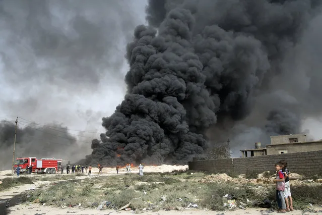 In this Wednesday August 31, 2016 photo, Iraqi firefighters battle large fire at oil wells as they trying to prevent the flames from reaching the residential neighborhoods in Qayara, Iraq. Oil wells on the edge of Qayara burn days after the key town south of was retaken from the Islamic State group by Iraqi ground forces backed by U.S.-led coalition airpower. Iraq’s prime minister pledges Mosul will be retaken this year. (Photo by AP Photo)