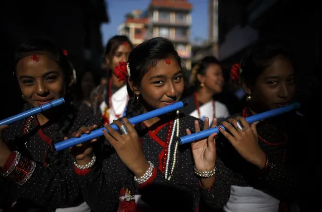 Girls play flutes as part of the Newari New Year parade that falls during the Tihar festival, also called Diwali, in Kathmandu October 24, 2014. The Newar community observes the start of their Newari New Year 1134, in accordance with their lunar calendar, by worshipping their spiritual selves in a ritual known as “mahapuja”. (Photo by Navesh Chitrakar/Reuters)