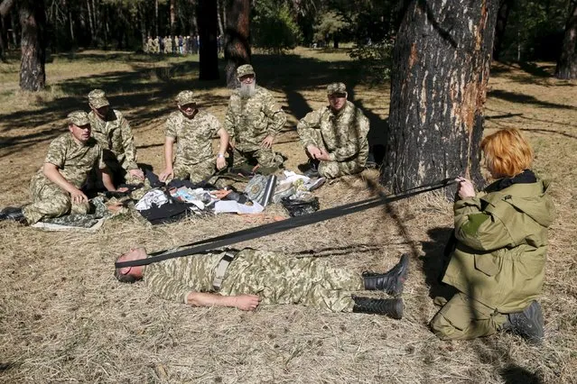 Priests of the Ukrainian Orthodox Church of Kiev Patriarchate listen to an instructor (R) as they take part in tactical medical exercises, before heading to the area of a military conflict in eastern regions of Ukraine to serve as army chaplains, in Kiev, Ukraine, October 1, 2015. (Photo by Valentyn Ogirenko/Reuters)