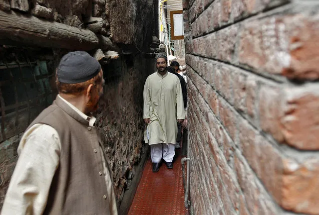 Mirwaiz Umar Farooq (C), chairman of Kashmir's moderate faction of All Parties Hurriyat (Freedom) Conference (APHC), walks through a narrow alley in Srinagar August 14, 2013. (Photo by Danish Ismail/Reuters)