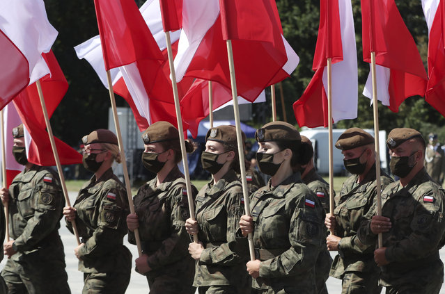 Polish soldiers hold national flags as Poland marks the centennial of the Battle of Warsaw, a Polish military victory in 2020 that stopped the Russian Bolshevik march toward the west, in Warsaw, Poland, Saturday August 15, 2020. U.S. Secretary of State Mike Pompeo attended as he wrapped up a visit to central Europe. (Photo by Czarek Sokolowski/AP Photo)