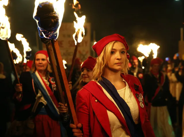 Participants in costumes hold burning torches as they take part in one of a series of processions during Bonfire night celebrations in Lewes, southern England November 5, 2014. The processions and bonfire mark the uncovering of Guy Fawkes' “Gunpowder Plot” to blow up the Houses of Parliament in 1605, and commemorate the memory of Lewes' seventeen Protestant martyrs. (Photo by Luke MacGregor/Reuters)