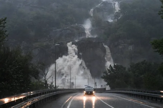 A car is driving on the flooded cantonal road in Cresciano on Saturday, August 29, 2020. In Switzerland it rains sometimes heavily from Friday to Sunday evening, in Ticino well over 200 liters per square meter. (Photo by Alessandro Crinari/Ti-Press/Keystone)