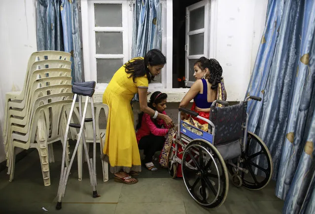 A competitor receives help from relatives as she gets ready backstage during the Miss Wheelchair India beauty pageant in Mumbai November 26, 2014. (Photo by Danish Siddiqui/Reuters)