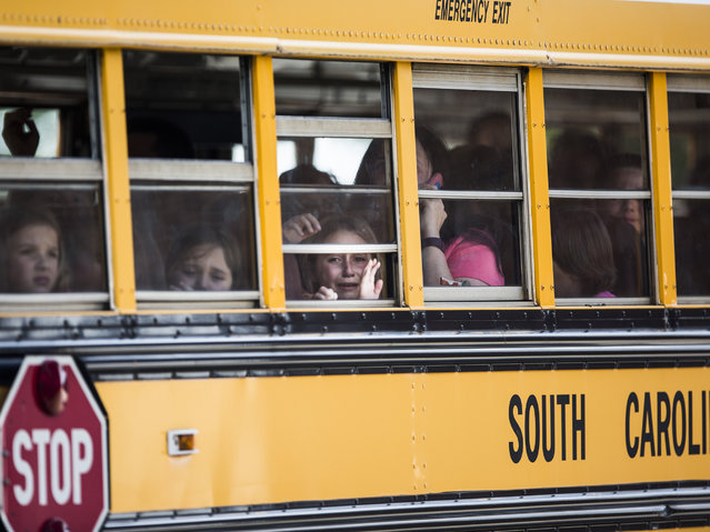 A Townville Elementary student looks out of the window of a school bus as she and her classmates are transported to Oakdale Baptist Church, following a shooting at Townville Elementary in Townville Wednesday, September 28, 2016. A teenager killed his father at his home Wednesday before going to the nearby elementary school and opening fire with a handgun, wounding two students and a teacher, authorities said. (Photo by Katie McLean/The Independent-Mail via AP Photo)