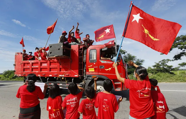 Supporters of Myanmar leader Aung San Suu Kyi's National League for Democracy (NLD) party waves the party flag and cheers from a truck during an election campaign for next month's general election, Wednesday, October 21, 2020, in Naypyitaw, Myanmar. (Photo by Aung Shine Oo/AP Photo)