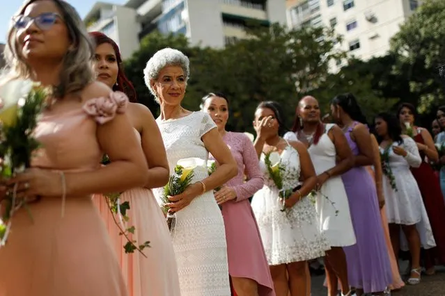 Brides arrive at a public square to participate in a community wedding ceremony during Valentine's Day in Caracas, Venezuela on February 14, 2023. (Photo by Leonardo Fernandez Viloria/Reuters)