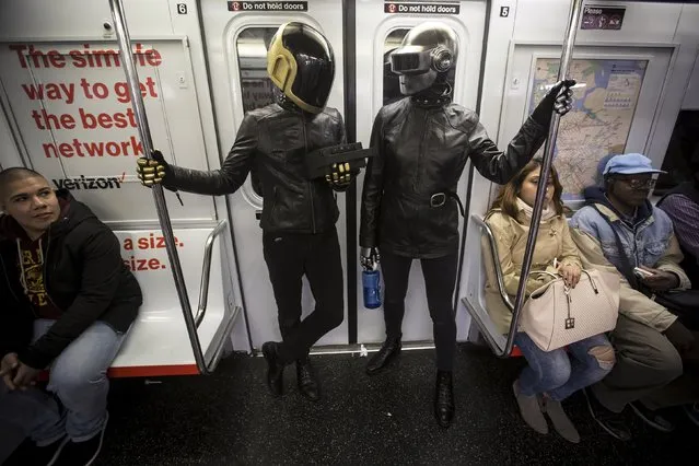 A couple dressed up as musical act Daft Punk ride the shuttle subway at Times Square station in the Manhattan borough of New York, October 31, 2015. (Photo by Carlo Allegri/Reuters)