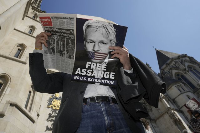 A protester reads a newspaper outside the High Court in London, Monday, May 20, 2024. A British court has ruled that WikiLeaks founder Julian Assange can appeal against an order that he be extradited to the U.S. on espionage charges.(Photo by Kin Cheung/AP Photo)