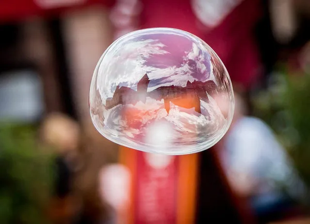 A blurred panaroma of Roemerberg historic center is reflected in a soap bubble in Frankfurt am Main, Germany, 09 July 2015. (Photo by Frank Rumpenhorst/EPA)