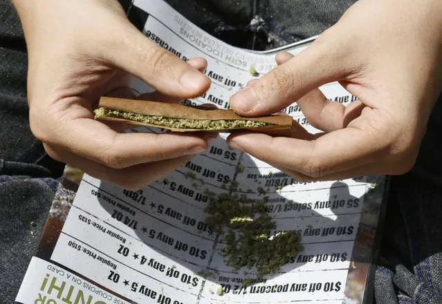 A participant rolls a marijuana filled blunt at the 4/20 marijuana holiday in Civic Center Park in downtown Denver April 20, 2013. (Photo by Rick Wilking/Reuters)