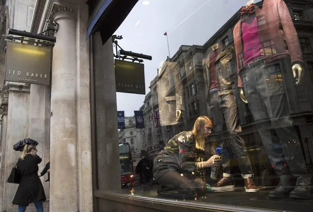 A shop worker adjusts a window display in a  Ted Baker store in London, Britain October 6, 2015. (Photo by Neil Hall/Reuters)