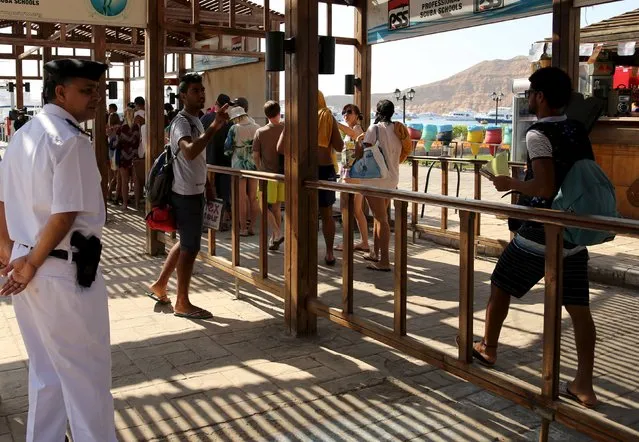 Police stands guard as tourists get their bags checked before they go for an excursion at a small port of the Red Sea resort of Sharm el-Sheikh, November 7, 2015. (Photo by Asmaa Waguih/Reuters)