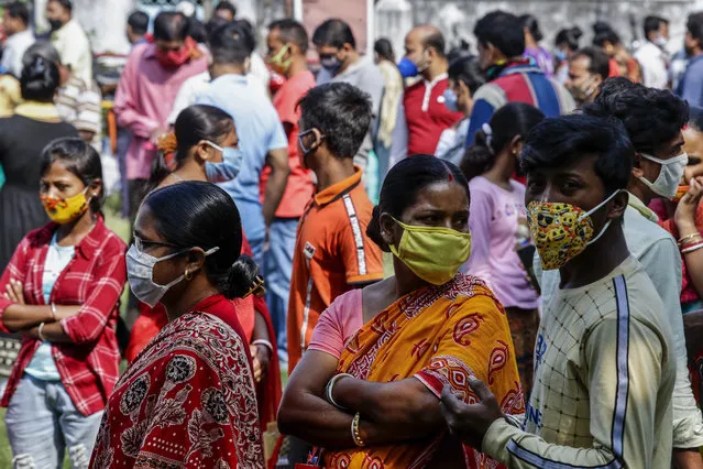People, belonging to scheduled caste, scheduled tribe and other backward classes stand in queue to claim their rights at a certification camp by the backward classes welfare department in Kolkata, India, Sunday, November 22, 2020. India's total number of coronavirus cases since the pandemic began has crossed 9 million. (Photo by Bikas Das/AP Photo)
