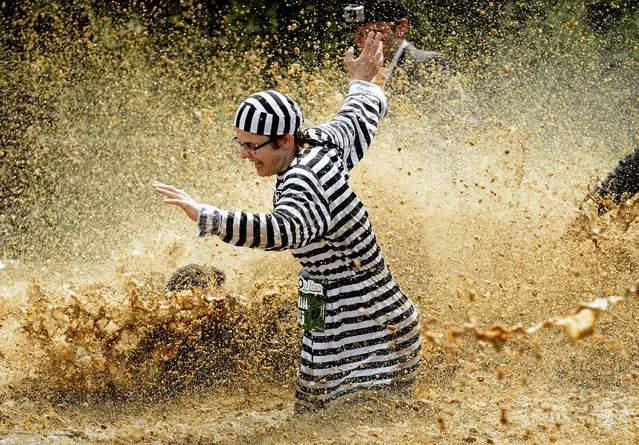 Participants in the “Barjot Run” make their way through the mud in Biere, Switzerland, on May 4, 2013. (Photo by Laurent Gillieron/Keystone)