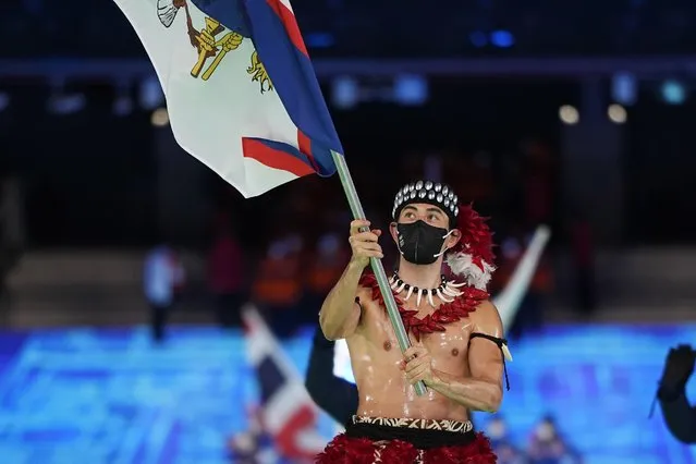 Nathan Crumpton, of American Samoa, carries his national flag into the stadium during the opening ceremony of the 2022 Winter Olympics, Friday, February 4, 2022, in Beijing. (Photo by Jae C. Hong/AP Photo)
