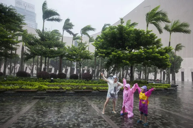 People walk through gale-force winds as Typhoon Haima makes landfall on the South China coast, in Hong Kong, China, 21 October 2016. (Photo by Alex Hofford/EPA)