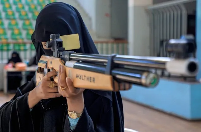 A woman athlete aims an air rifle while competing in a local shooting championship in Yemen's Huthi rebel-held capital Sanaa on January 3, 2023. (Photo by Mohammed Huwais/AFP Photo)