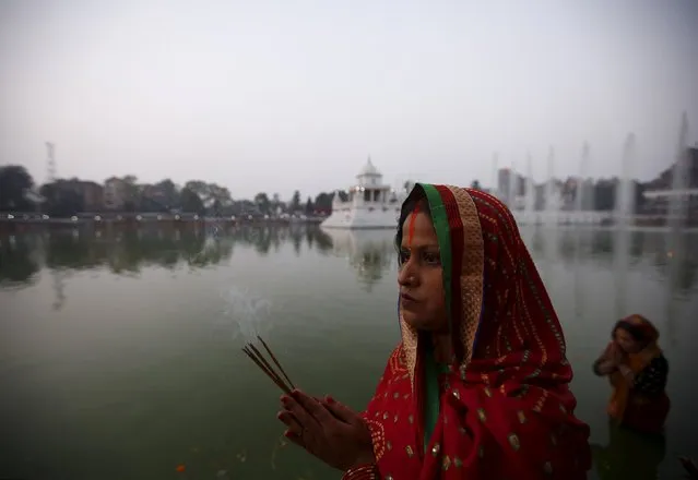 A devotee offers prayers as she waits for the rising sun during the "Chhat" festival in Kathmandu, Nepal November 18, 2015. (Photo by Navesh Chitrakar/Reuters)