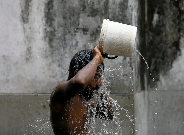 A man bathes in the morning before the start of his day at a public well in Colombo, Sri Lanka September 23, 2016. (Photo by Dinuka Liyanawatte/Reuters)