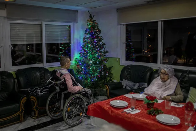Two elders wait Christmas eve dinner at an elderly care home in Pozuelo de Alarcon, outskirts of Madrid, Thursday, December 24, 2020. Many of the elderly in the residence haven't celebrate Christmas eve with their relatives to prevent the spread of coronavirus (Photo by Bernat Armangue/AP Photo)