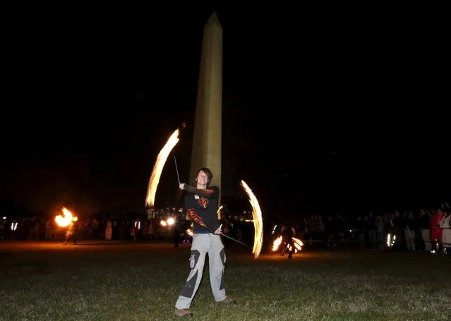 Performer Ben Drexler spins a pair of "fire poi" in front of the Washington Monument during a 48-hour vigil called "Catharsis on the Mall: A Vigil for Healing the Drug War" on the U.S. National Mall in Washington November 22, 2015. (Photo by Jim Bourg/Reuters)