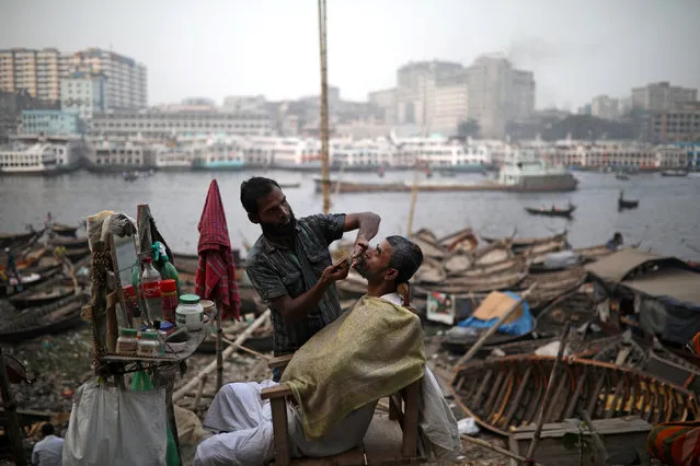 A man has his beard groomed at a street saloon at the bank of Buriganga river in Dhaka, Bangladesh, February 5, 2018. (Photo by Mohammad Ponir Hossain/Reuters)