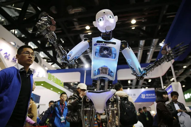 Visitors watch a robot on shown during the World Robot Conference at China national convention center in Beijing city, China, 23 November 2015. (Photo by Wu Hong/EPA)