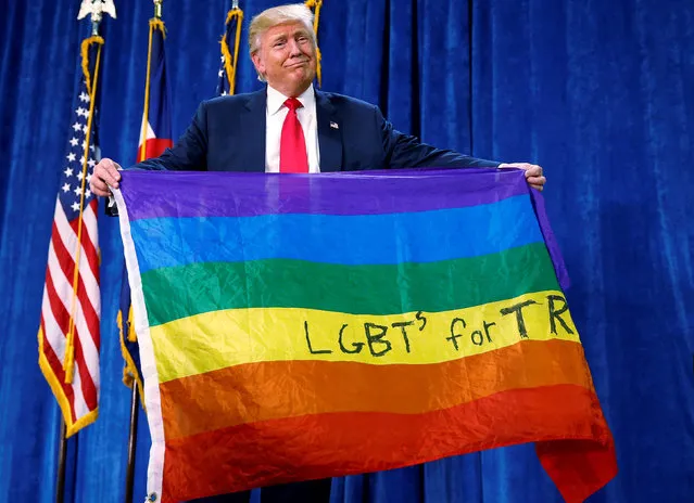 Republican presidential nominee Donald Trump holds up a rainbow flag with “LGBTs for TRUMP” written on it at a campaign rally in Greeley, Colorado, U.S. October 30, 2016. (Photo by Carlo Allegri/Reuters)