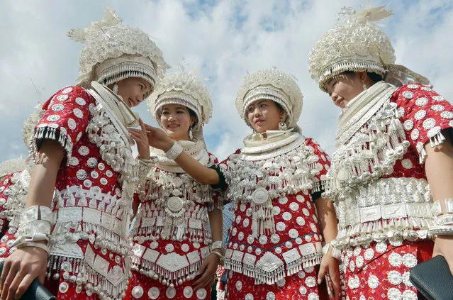 Chinese women of Miao ethnic minority dressed in traditional silver-decorated clothes and headwears take part in a celebration for the Miao Lusheng Festival in Gulong town, Huangping county, Qiandongnan Miao and Dong Autonomous Prefecture, southwest China's Guizhou province on October 27, 2016. The Miao Lusheng Festival is the most ceremonious traditional festival celebrated on the grandest scale in Zhouxi, Kaili City, and Gulong town in Huangping county. Hundreds and thousands of Miao girls wearing silver-decorated clothes and head ornaments dance together to the rhythms, forming one circle after another together on the lusheng playing ground. (Photo by Imaginechina/Rex Features/Shutterstock)