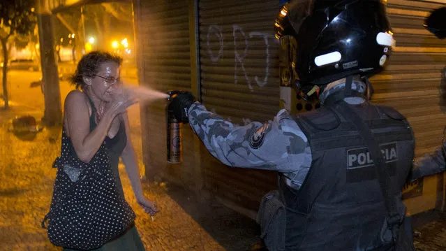 A military police pepper-sprays a protester during a demonstration in Rio de Janeiro, Brazil, Monday, June 17, 2013. Protesters massed in at least seven Brazilian cities Monday for another round of demonstrations voicing disgruntlement about life in the country, raising questions about security during big events like the current Confederations Cup and a papal visit next month. (Photo by Victor R. Caivano/AP Photo)