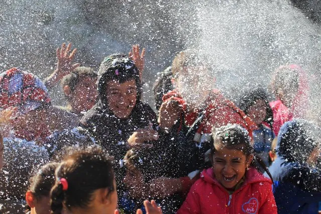 Internally displaced children play with foam sprayed by volunteers entertaining them at a makeshift camp in Latakia province, near the Syrian-Turkish border, Syria December 4, 2015. (Photo by Ammar Abdullah/Reuters)