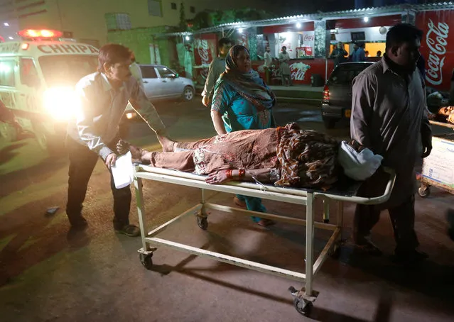 A woman is wheeled from an ambulance after an explosion in at the Shah Noorani Shrine in Baluchistan, at a hospital in Karachi, Pakistan, November 12, 2016. (Photo by Akhtar Soomro/Reuters)