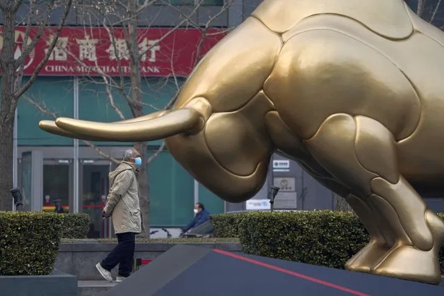 An elderly Chinese man wearing mask passes by a sculpture depicting a bull in the financial district in Beijing on Thursday, March 4, 2021. The catchword “rejuvenation” has been tucked into the major speeches at China's biggest political event of the year, the meeting of its 3,000-member legislature. Rejuvenation is repeated like a mantra, even woven into a sprawling exhibit at the national art museum marking the Year of the Ox in the Chinese zodiac. (Photo by Ng Han Guan/AP Photo)