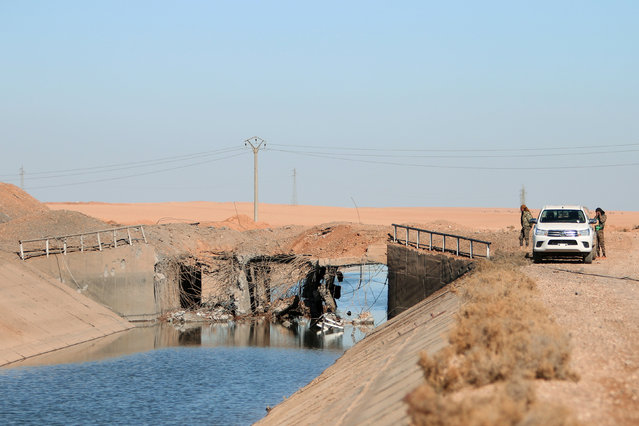 Syria Democratic Forces (SDF) fighters stands near the damaged bridge of Balikh river near the town of Tel al-Saman in the northern rural area of Raqqa, Syria November 17, 2016. (Photo by Rodi Said/Reuters)