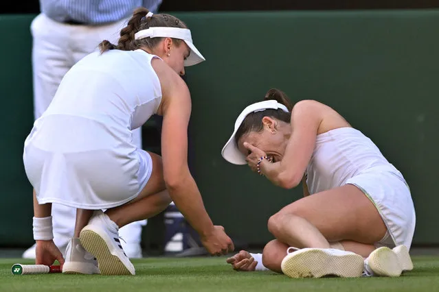 Kazakhstan's Elena Rybakina (L) checks on France's Alize Cornet after resulting injured during their women's singles tennis match on the fourth day of the 2023 Wimbledon Championships at The All England Tennis Club in Wimbledon, southwest London, on July 6, 2023. (Photo by Glyn Kirk/AFP Photo)