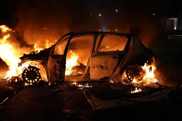 A vehicle burns destroyed during a protester in Nanterre, west of Paris, on June 27, 2023, after French police killed a teenager who refused to stop for a traffic check in the city. The 17-year-old was in the Paris suburb early on June 27 when police shot him dead after he broke road rules and failed to stop, prosecutors said. The event has prompted expressions of shock and questions over the readiness of security forces to pull the trigger. (Photo by Zakaria Abdelkafi/AFP Photo)