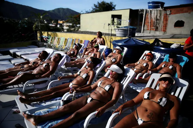 Women wearing their masking tape bikinis, sunbathe to have the perfect bikini mark (“marquinha” in Portuguese), at the Erika Bronze spa in Rio de Janeiro, Brazil, November 21, 2016. Brazilian women in search of the perfect bikini tan line fashion tiny tanning suits out of black tape. (Photo by Pilar Olivares/Reuters)