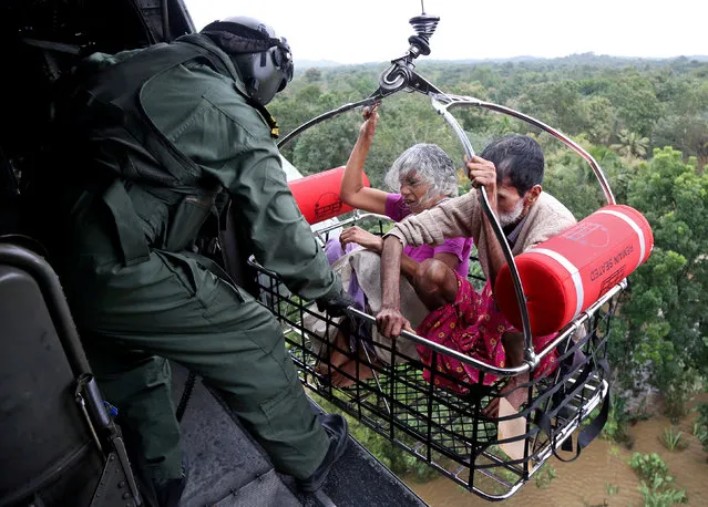 People are airlifted by the Indian Navy soldiers during a rescue operation at a flooded area in the southern state of Kerala, India, August 17, 2018. (Photo by Sivaram V/Reuters)