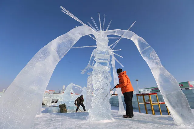 Workers carve ice art works at Harbin Ice and Snow World one day before the 32th Harbin International Ice and Snow Festival in Harbin city, China's northern Heilongjiang province, 04 January 2016. The festival will run from 05 January to 05 February. (Photo by Wu Hong/EPA)