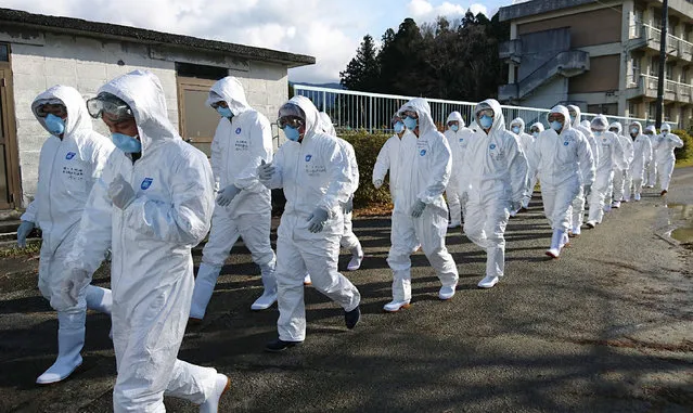 Wearing anti-virus suits, soldiers of the Ground Self Defense Force head for chicken farm in Sekikawa, Niigata prefecture, on November 29, 2016. 
Japan has begun slaughtering more than 330,000 farm birds to contain its first outbreaks of a highly contagious strain of avian flu in nearly two years. (Photo by AFP Photo/Ground Self Defense Force)