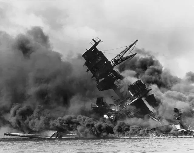 The forward superstructure of the sunken battleship USS Arizona burns after the Japanese raid on Pearl Harbor, December 7, 1941. (Photo by Reuters/U.S. Naval History and Heritage Command)