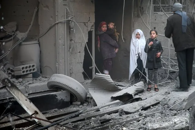 Children inspect damage in a site hit by what activists said were airstrikes carried out by the Russian air force in the town of Douma, eastern Ghouta in Damascus, Syria January 10, 2016. (Photo by Bassam Khabieh/Reuters)