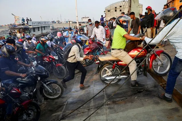 People on motorcycles rush to board a ferry at Mawa Ferry Terminal to get home to celebrate Eid al-Fitr, after the government imposed coronavirus disease (COVID-19) restrictions on long-route public transport, in Munshiganj, Bangladesh, May 12, 2021. (Photo by Mohammad Ponir Hossain/Reuters)